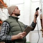 Man scans boxes with barcode scanner warehousing erp solutions can support barcoding